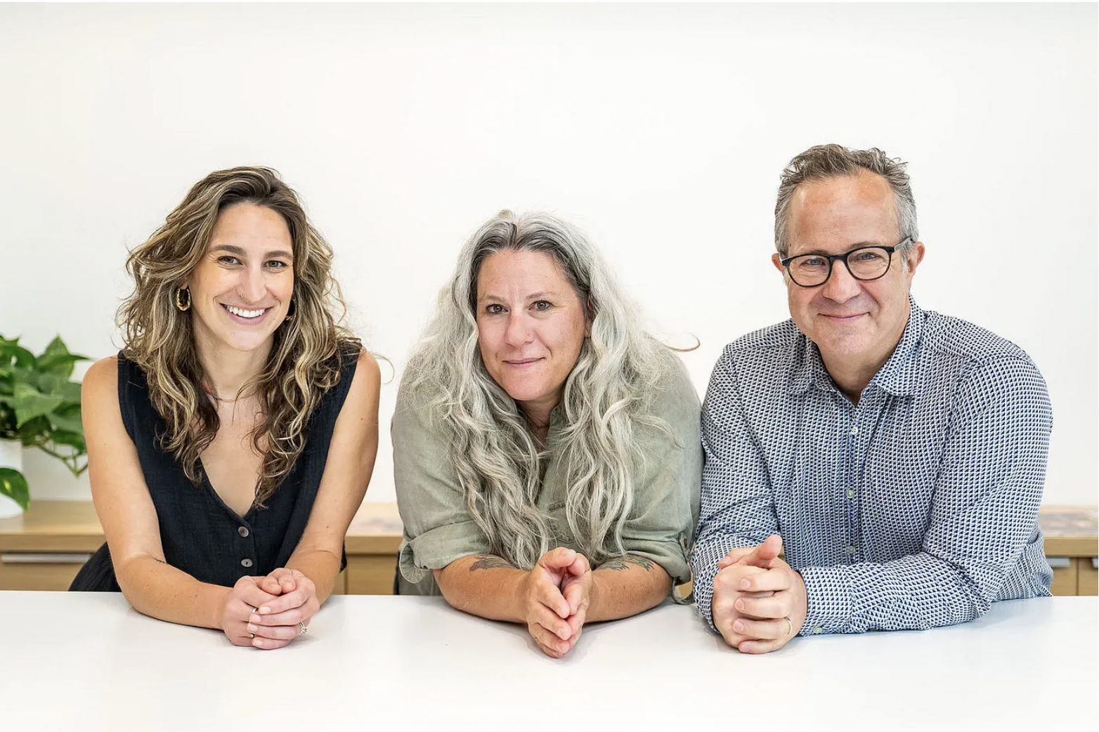 Bianca Taylor, Katie Sprenger and Lowell Robinson leaning on a white table